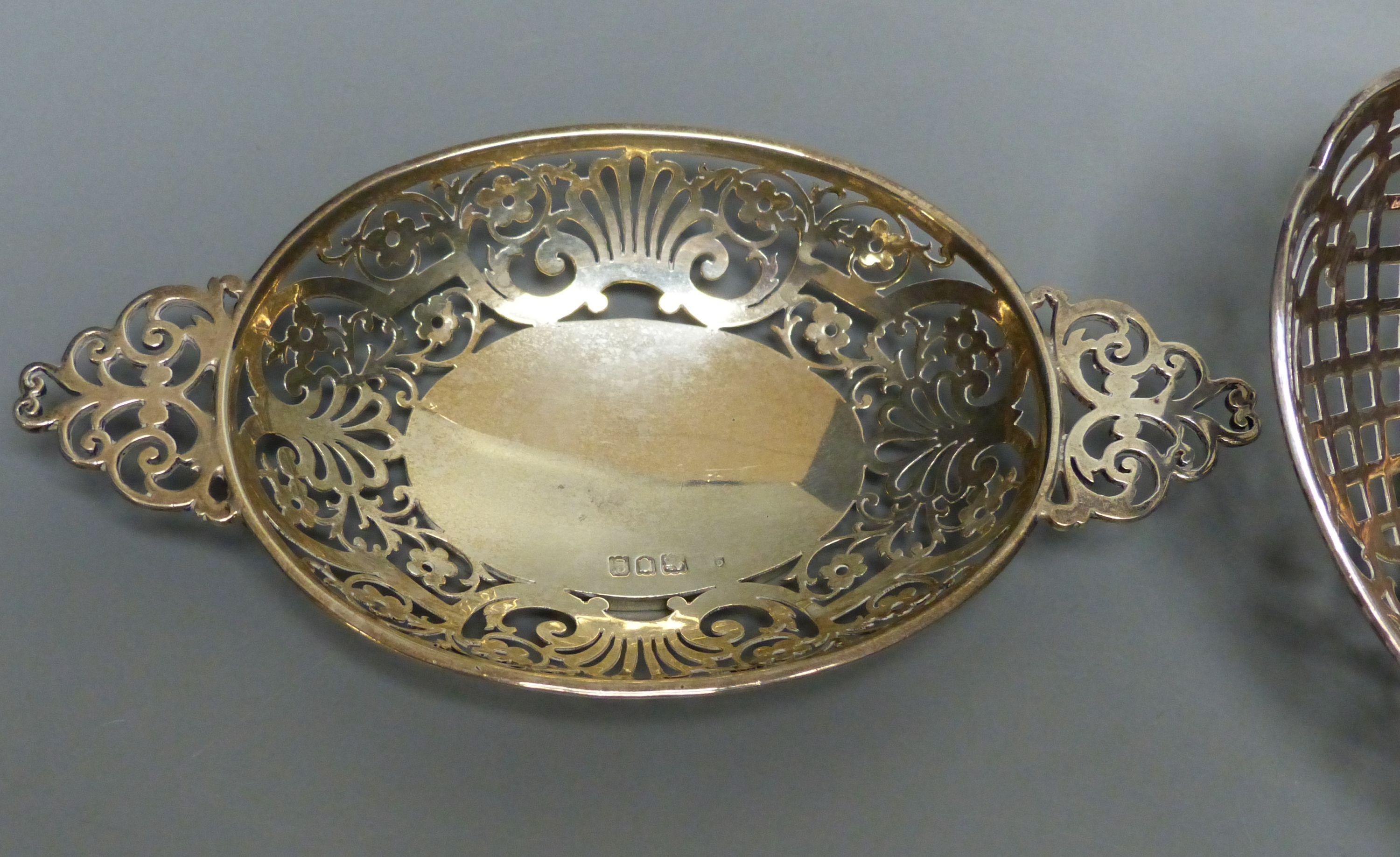 An Edwardian silver oval bon bon dish with pierced flower and scroll decoration and a Dutch white metal sweetmeat basket